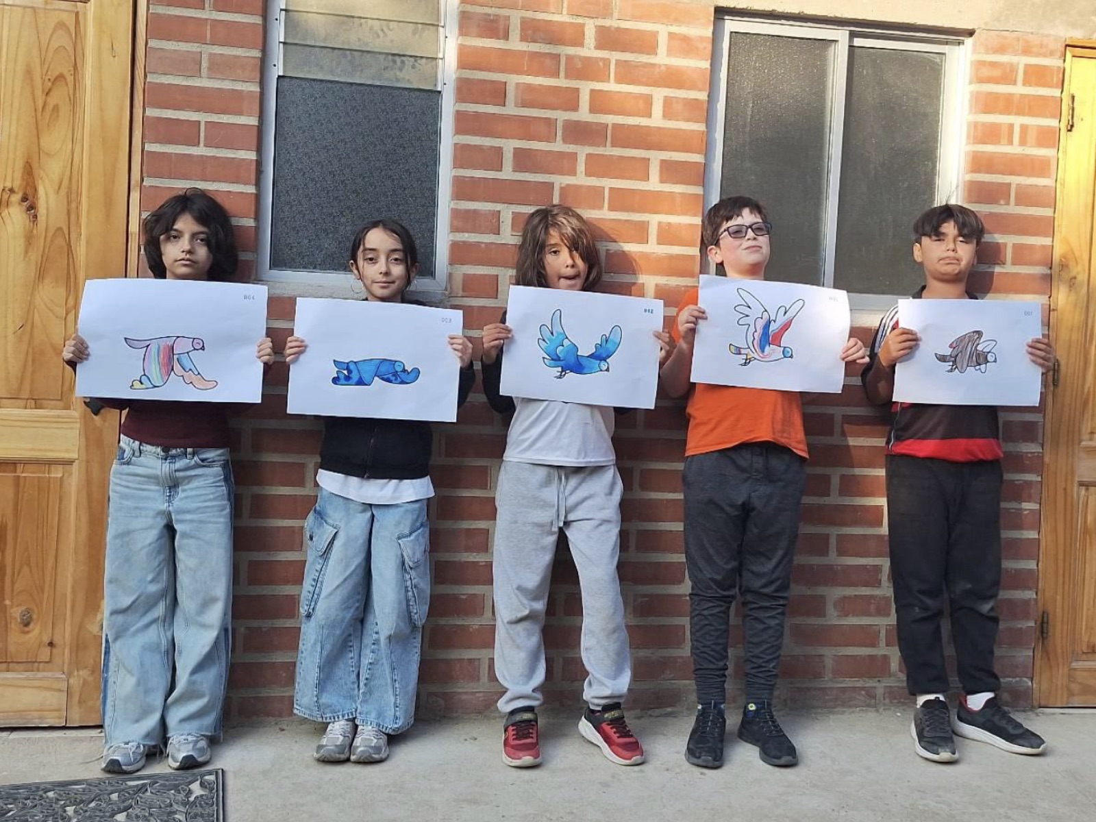 Grupo de estudiantes mostrando sus dibujos de personajes